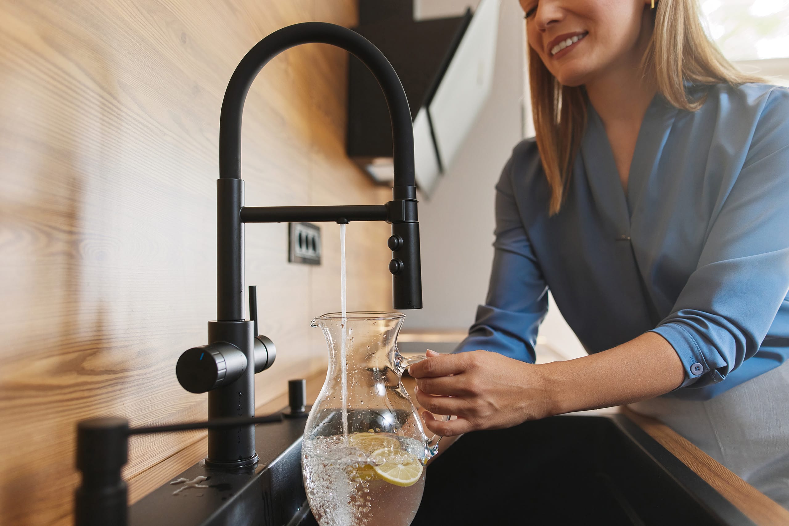 Eine Frau füllt einen Krug mit Osmosewasser